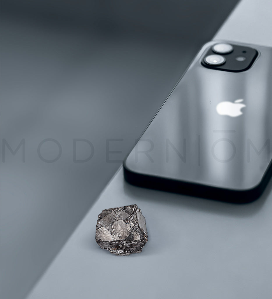 Elit Shungite stone next to silver iPhone