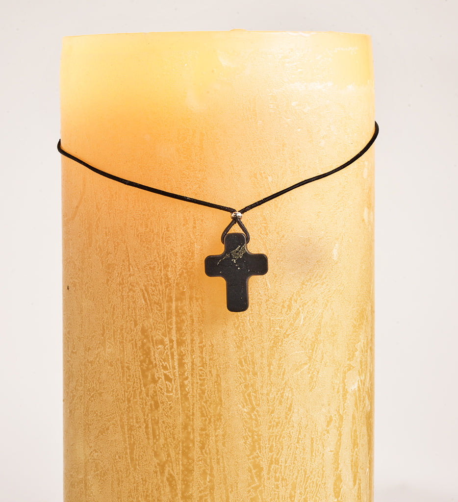 Shungite cross necklace on candle