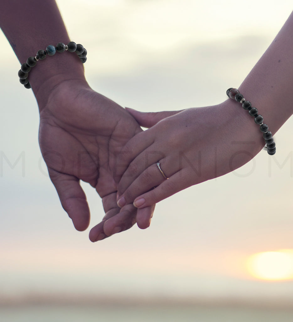 Couple holding hands, wearing 8-10mm bracelets for web therapy.