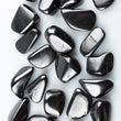 Load image into Gallery viewer, Shungite pebbles, polished and dark, against white background.