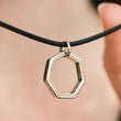 Load image into Gallery viewer, Silver hexagonal pendant on a black cord.