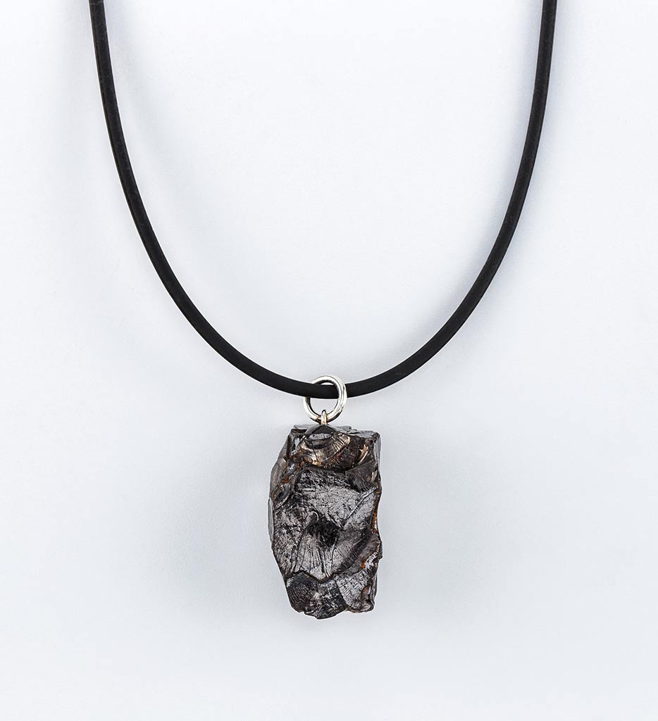 Unique raw stone pendant necklace on black cord.