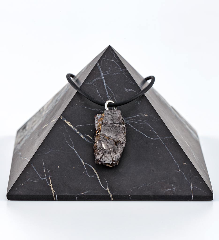 Raw stone pendant necklace on black pyramid