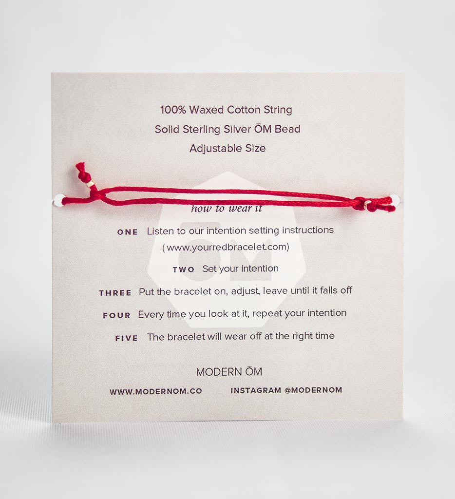 modern om red string bracelet back of packaging