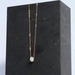 Load image into Gallery viewer, Gold necklace with geometric pendant on black stand