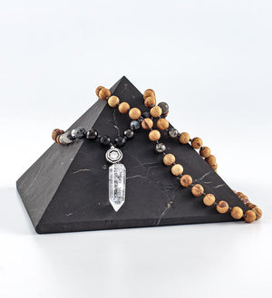 beautiful hand-made mala, palo santo and shungite beads, clear quartz, sterling silver, on a shungite pyramid
