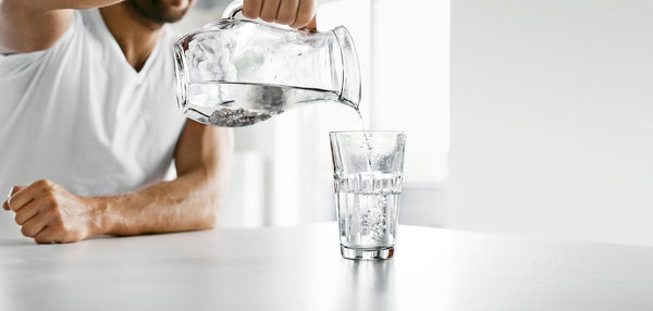 Man pouring water into glass, Landing Page slider image.