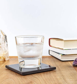 Glass of water on coaster with books