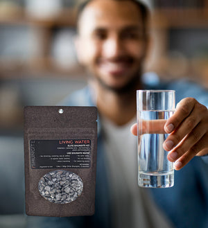 Man holding glass of water & shungite water kit
