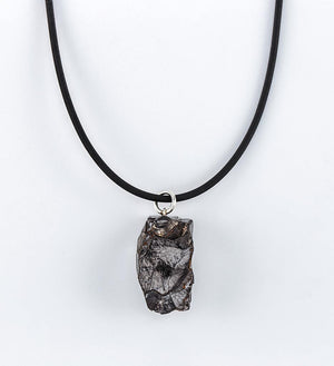 Unique raw stone pendant necklace on black cord.